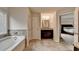 Bright bathroom featuring tub, tiled floors, and granite vanity at 4191 Secret Shoals Way, Buford, GA 30518