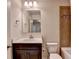 Bathroom featuring a brown vanity, a single sink, mirror, lighting, decorative tiles, and a toilet at 4191 Secret Shoals Way, Buford, GA 30518