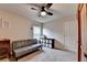 Bedroom featuring a gray sofa, carpet flooring, a ceiling fan, a window, and a white door at 4191 Secret Shoals Way, Buford, GA 30518