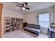 Bedroom featuring ceiling fan, bookshelves, carpet flooring, neutral walls and window bringing natural light at 4191 Secret Shoals Way, Buford, GA 30518