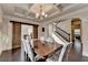 Elegant dining room featuring coffered ceiling and seating for six next to staircase at 4191 Secret Shoals Way, Buford, GA 30518