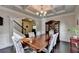 Elegant dining room features coffered ceiling and seating for six near staircase and built-in hutch at 4191 Secret Shoals Way, Buford, GA 30518