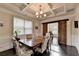 Formal dining area boasts dark wood floors, decorative trim, coffered ceiling, and barn door at 4191 Secret Shoals Way, Buford, GA 30518