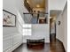 Bright foyer featuring hardwood floors, detailed trim work, staircase with iron railing, and elegant bench at 4191 Secret Shoals Way, Buford, GA 30518