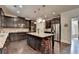 Gourmet kitchen with stainless appliances, granite countertops, dark cabinets, and central island with seating at 4191 Secret Shoals Way, Buford, GA 30518