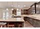 Open kitchen features an island with seating, granite counters, dark cabinets, and stainless steel appliances at 4191 Secret Shoals Way, Buford, GA 30518