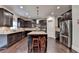 Gourmet kitchen with stainless appliances, granite countertops, dark cabinets, and central island with seating at 4191 Secret Shoals Way, Buford, GA 30518