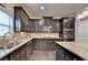 Gourmet kitchen featuring granite countertops, stainless steel appliances, and dark wood cabinets and floor at 4191 Secret Shoals Way, Buford, GA 30518