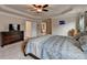 Spacious bedroom features a tray ceiling, fan, carpet, and dresser with TV at 4191 Secret Shoals Way, Buford, GA 30518