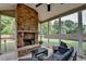 Cozy sunroom with a brick fireplace, ceiling fan and wicker furniture for relaxing at 4191 Secret Shoals Way, Buford, GA 30518