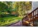 Landscaped backyard with lush greenery, with a wooden staircase to a small deck on the rear of the home at 511 Oakview Rd, Decatur, GA 30030
