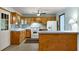 Well-lit kitchen with wood cabinets, a breakfast bar, modern appliances, and tile flooring with a ceiling fan at 511 Oakview Rd, Decatur, GA 30030