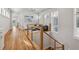 Upstairs hallway with wood floors, decorative railing and natural light, offering a glimpse into the cozy sitting area at 6815 Halcyon Way, Alpharetta, GA 30005