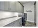 This laundry room features gray cabinets and modern washer and dryer at 6815 Halcyon Way, Alpharetta, GA 30005