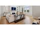 Bright living room features hardwood floors, large windows, fireplace, and comfortable seating area at 6815 Halcyon Way, Alpharetta, GA 30005