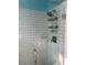 Shower featuring a glass door, white subway tiles, and a rainfall shower head at 1238 Trenton St, Atlanta, GA 30316
