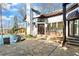 Backyard stone patio with an infinity pool, leading to exterior house with brick accents and multiple windows at 1352 Middlesex Ne Ave, Atlanta, GA 30306