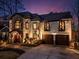 Gorgeous two-story home with stone and stucco detailing, enhanced by lovely landscaping and warm, inviting lighting at 1352 Middlesex Ne Ave, Atlanta, GA 30306