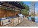 Outdoor kitchen next to an infinity pool, complete with stone facade, stainless steel grill, and counterspace at 1352 Middlesex Ne Ave, Atlanta, GA 30306