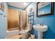 Cozy bathroom showcasing blue walls and a shower with tan tile surround at 1417 Sterlingbrooke Dr, Powder Springs, GA 30127