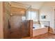 Bathroom featuring separate glass shower and a soaking tub with tiled surround and a window at 1417 Sterlingbrooke Dr, Powder Springs, GA 30127