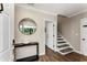 Inviting entryway featuring wood floors, stairs, and a modern round mirror above a black console table at 2356 Defoors Ferry Nw Rd, Atlanta, GA 30318