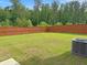 Large backyard with wooded perimeter, wooden fence, and AC unit at 3062 Hawthorn Farm Blvd, Loganville, GA 30052