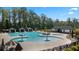 Community pool with splash features, lounge chairs, and cabanas with a nearby clubhouse at 3062 Hawthorn Farm Blvd, Loganville, GA 30052