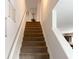 Carpeted staircase with white railing leading to the upper level at 3062 Hawthorn Farm Blvd, Loganville, GA 30052