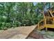 Spacious backyard featuring lush greenery and an elevated deck with stairs at 3715 Horizon Ct, Cumming, GA 30041