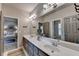 Bathroom with double vanity sinks and a large mirror, next to an open door into a bedroom at 3715 Horizon Ct, Cumming, GA 30041
