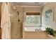 Bathroom showcasing a soaking tub beneath a window, walk-in shower, and stylish decor at 3715 Horizon Ct, Cumming, GA 30041