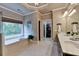Elegant bathroom with a soaking tub by a window, double vanity, and access to a walk-in closet, offering luxury and convenience at 3715 Horizon Ct, Cumming, GA 30041