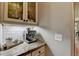 Convenient coffee bar area with granite countertop, stylish backsplash, and elegant display cabinets at 3715 Horizon Ct, Cumming, GA 30041