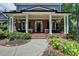 Inviting brick porch with elegant columns, offering a relaxing outdoor space with stylish seating and planters at 3715 Horizon Ct, Cumming, GA 30041