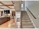 View of the staircase and the living room with coffered ceilings, stone fireplace and built-in shelving at 3715 Horizon Ct, Cumming, GA 30041