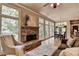Comfortable living room with a stone fireplace, large windows, and hardwood floors at 3715 Horizon Ct, Cumming, GA 30041