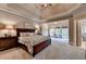 Spacious main bedroom with a trey ceiling, sitting area with a view, and ample space, creating a luxurious retreat at 3715 Horizon Ct, Cumming, GA 30041