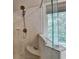 Walk-in shower features updated fixtures, white tiling, built-in seat and clear glass at 3715 Horizon Ct, Cumming, GA 30041