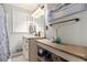 Bright bathroom with a white vanity, granite countertop, and decorative shelving unit for added storage at 4715 Howard Dr, Powder Springs, GA 30127