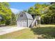 Two-story garage with white garage doors, exterior stairs, and a charming upper level at 4715 Howard Dr, Powder Springs, GA 30127