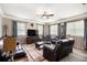 Living room with neutral paint, crown molding, large windows and dark brown leather furniture at 4715 Howard Dr, Powder Springs, GA 30127