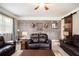 Spacious living room with exposed brick accent wall, cozy seating, and a ceiling fan at 4715 Howard Dr, Powder Springs, GA 30127