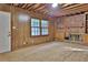 Unfinished basement with wood paneling, brick fireplace, and natural light from two windows at 1512 Pine Cir, Lawrenceville, GA 30044