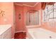 A bathroom with a glass shower, bathtub, and decorative window at 1640 Donovans Nw Rdg, Kennesaw, GA 30152