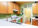 Galley kitchen with wood cabinets, mosaic tile backsplash, and a view to the laundry room at 1640 Donovans Nw Rdg, Kennesaw, GA 30152