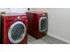 Bright laundry room with red LG washer and dryer on wood-look floors at 2837 Lakewater Way, Snellville, GA 30039