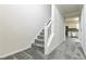 Carpeted staircase with white railing, leading to second floor and hallway with kitchen view at 2837 Lakewater Way, Snellville, GA 30039