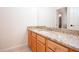 Bathroom with granite countertop on wood vanity, showing neutral tile and view into the hallway at 3333 N Hembree Rd, Marietta, GA 30062