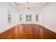 Bright bedroom featuring tray ceilings, many windows, and hardwood flooring at 3333 N Hembree Rd, Marietta, GA 30062